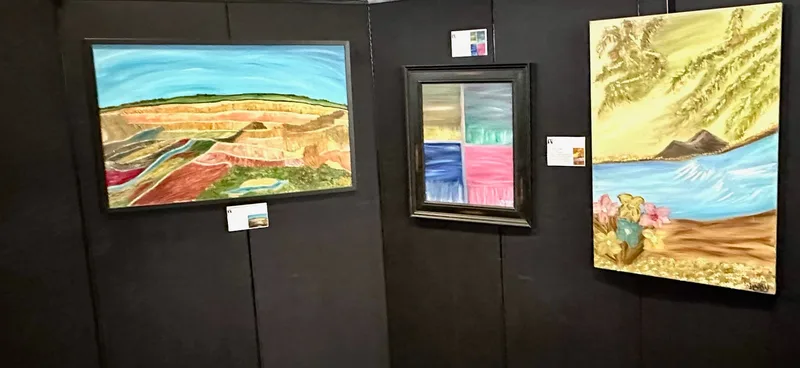 A layered landscape, a four-color study, and a lakeside painting on display.