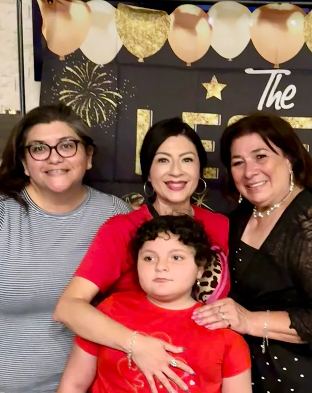 Dora smiling with family members.